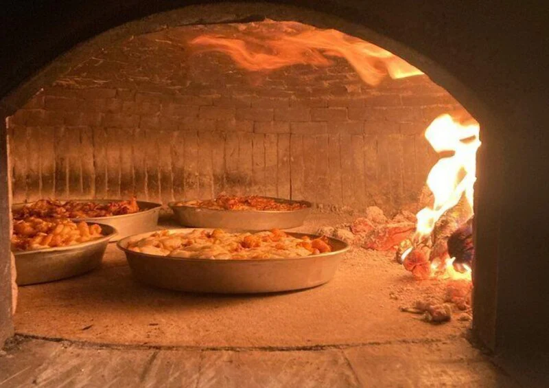 Baked pasta dishes inside the traditional wood-fired oven at Casa Rispo