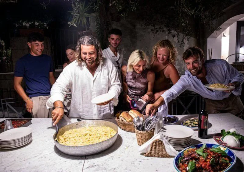 Roberto Rispo serving fresh pasta to guests on the terrace at night
