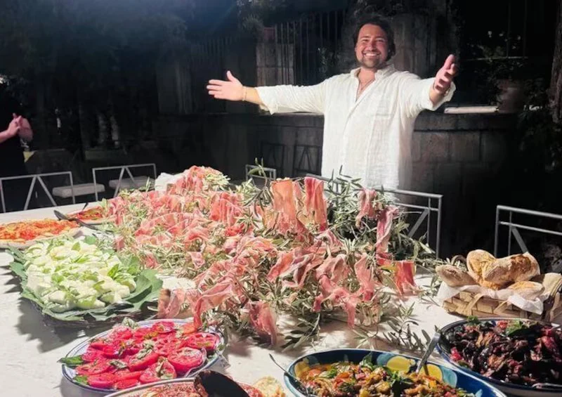 Roberto Rispo welcoming guests to an outdoor aperitivo spread